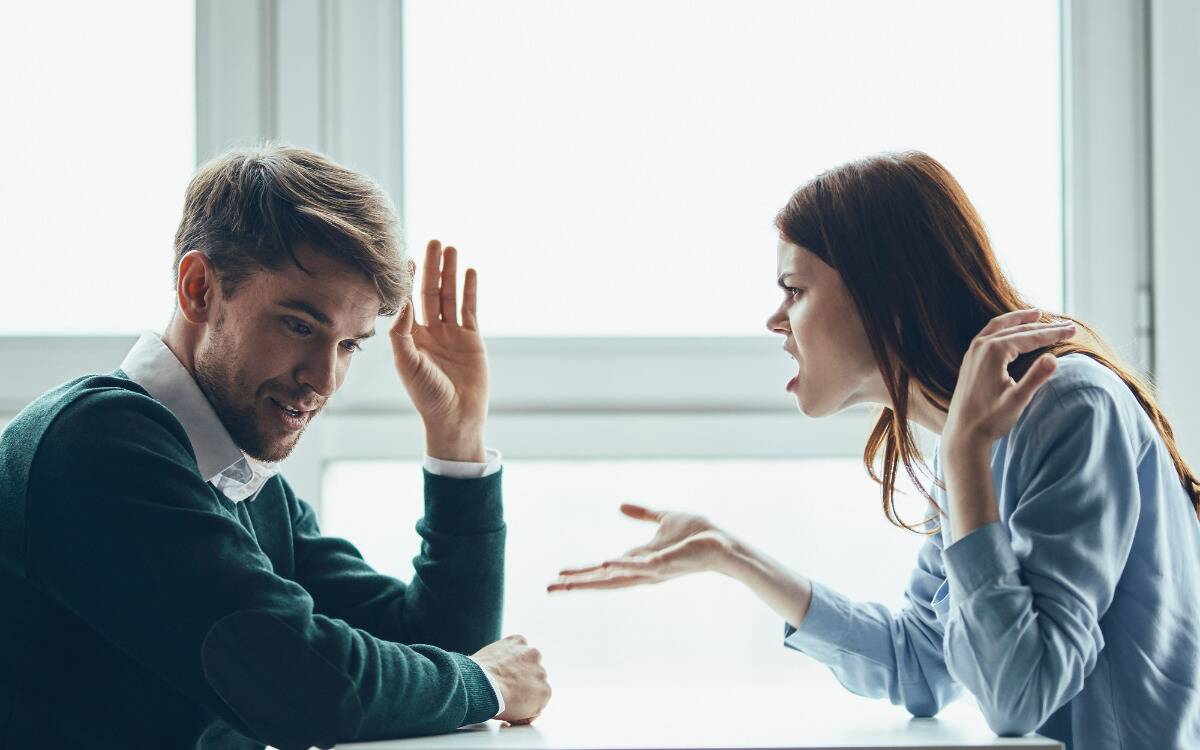 A man and woman fighting over a table.