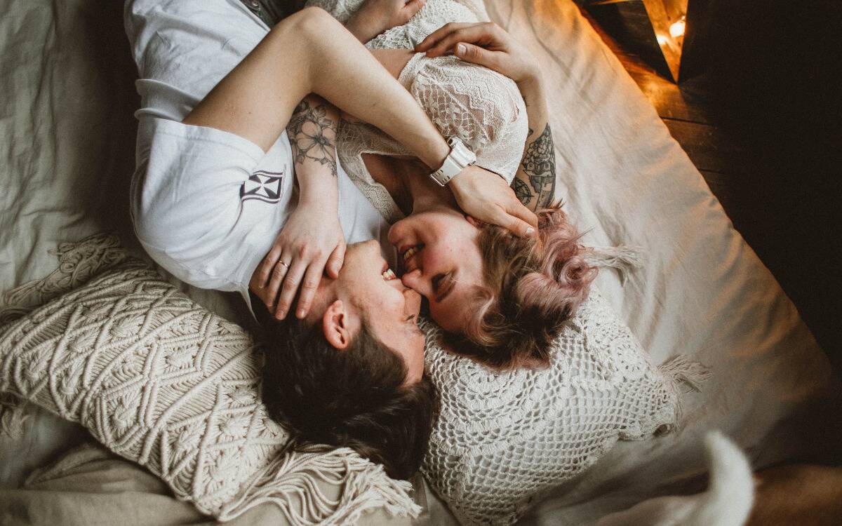 A woman cuddling together in bed.