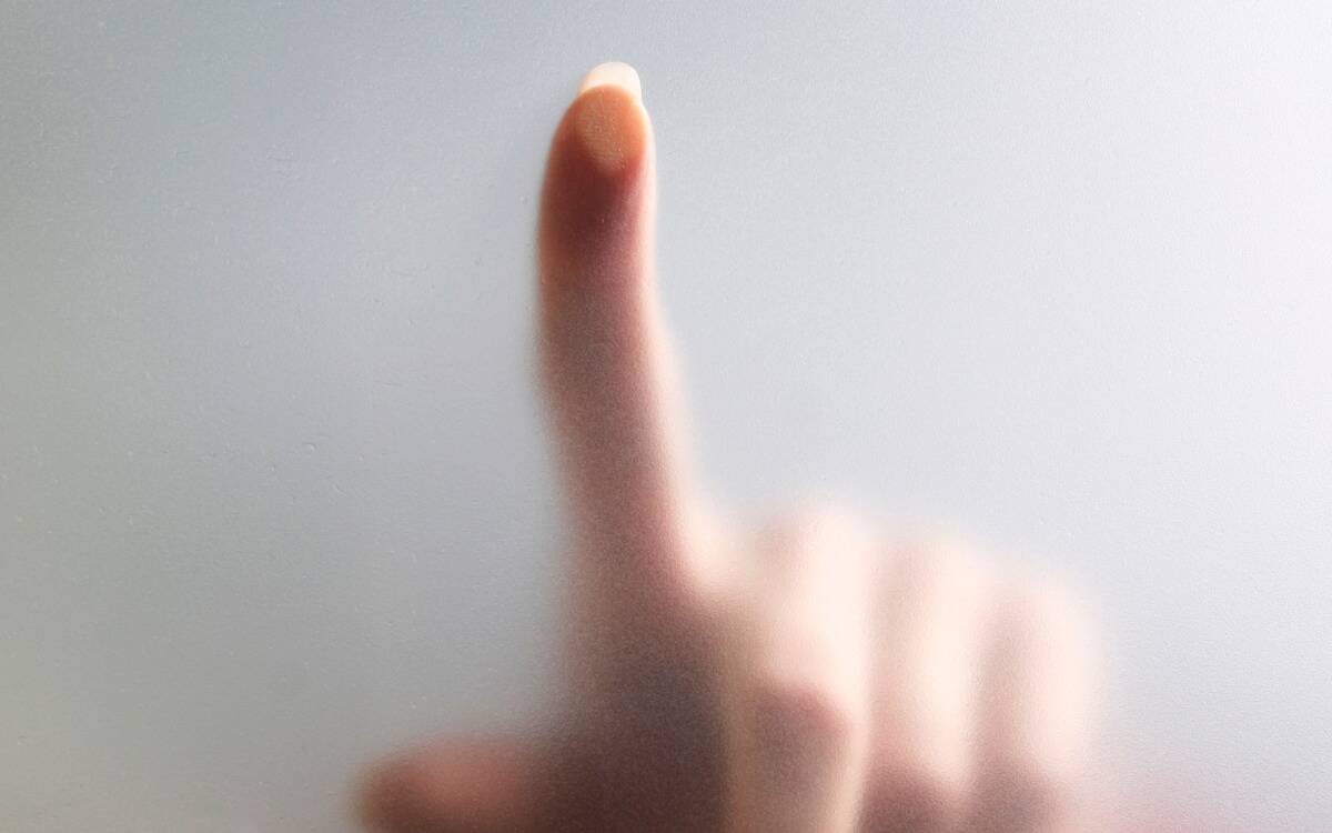 Someone pressing their fingertip against frosted glass.