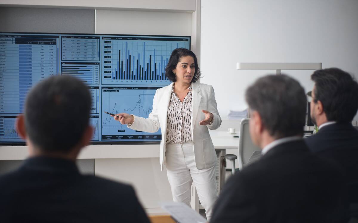 A woman giving a work presentation in a board room.
