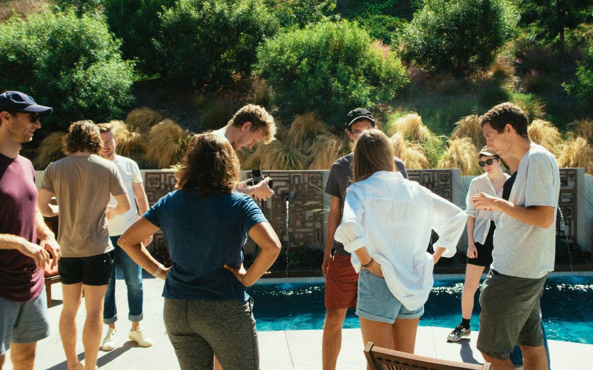 A group of friends having a get together in someone's backyard, surrounding a pool