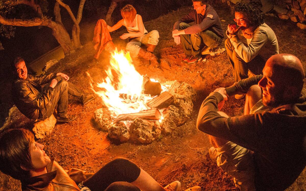 Friends sitting around a campfire.