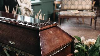 A photo of a coffin in a funeral parlor.
