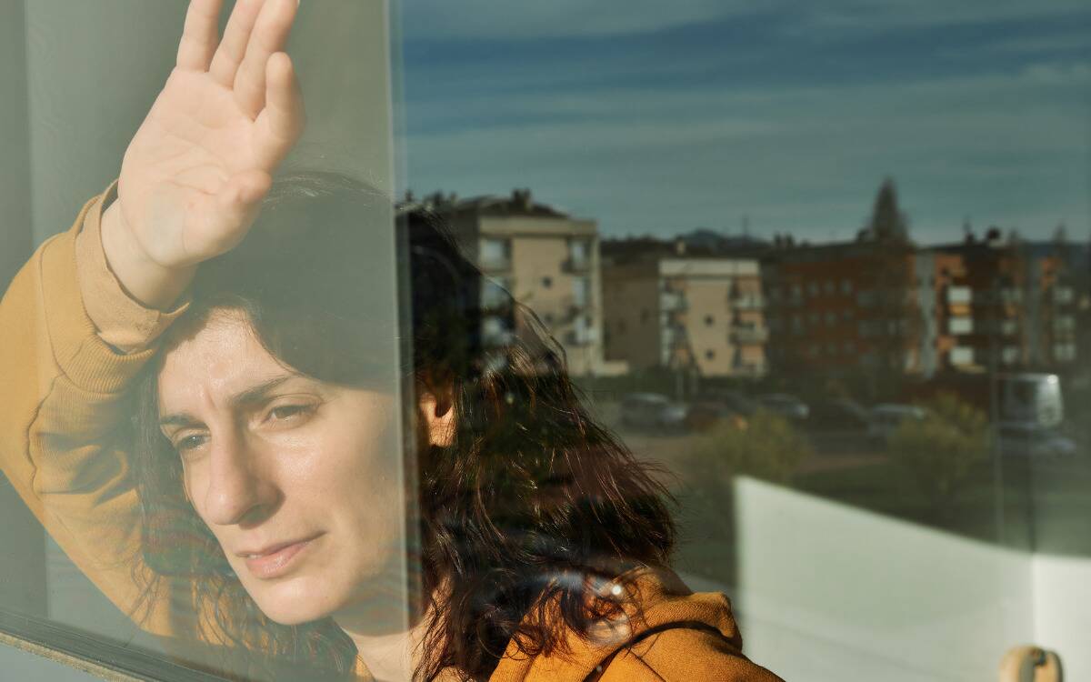 A woman looking forlornly out the window.