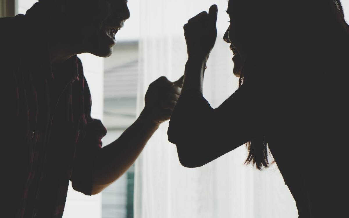 A silhouetted scene of a couple arguing with each other.