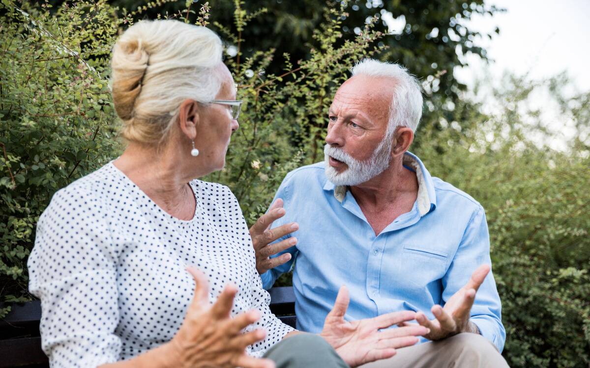 A couple sitting outside having a tense argument.