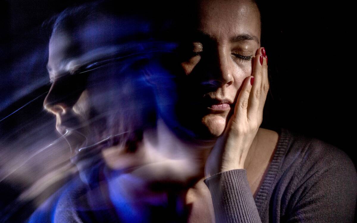 A woman with a hand on her cheek, a ghostly image of her yelling tearing away.