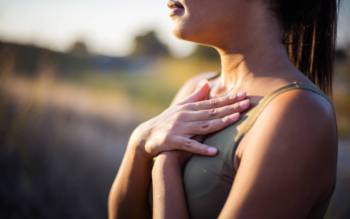 A woman with both of her hands over her chest.