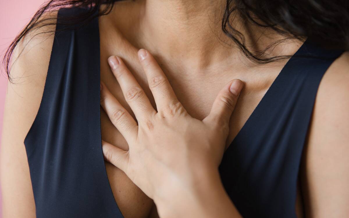 A woman placing a hand over her chest.