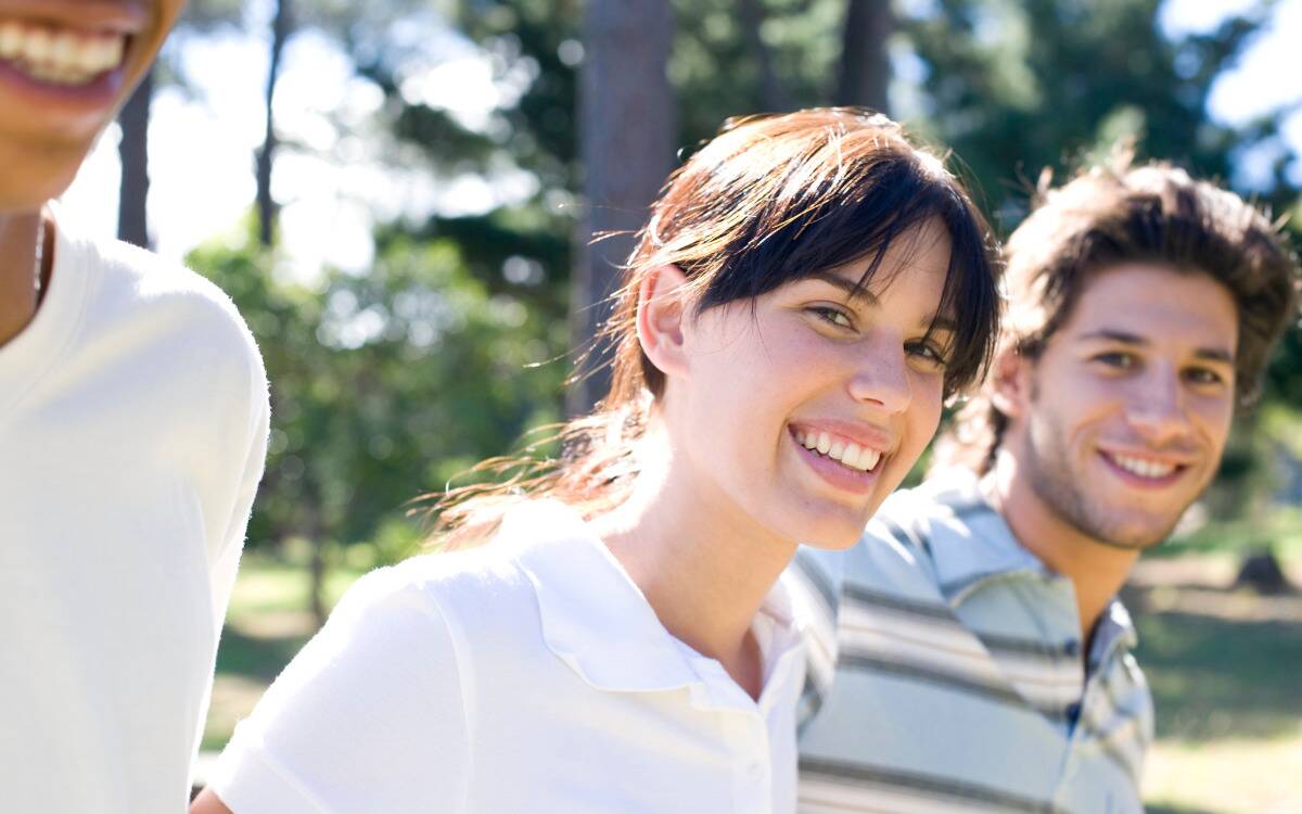 A woman walking with her friends, smiling at the camera.