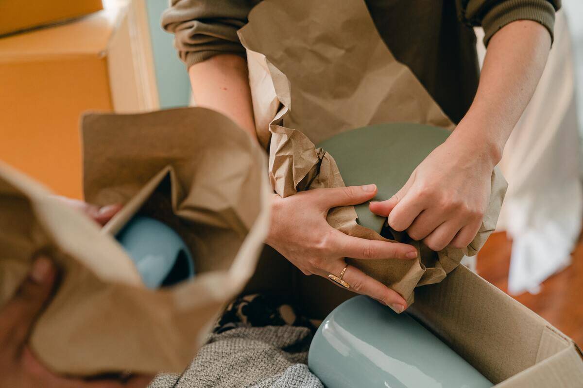 People wrapping their dishes in paper ahead of a move.