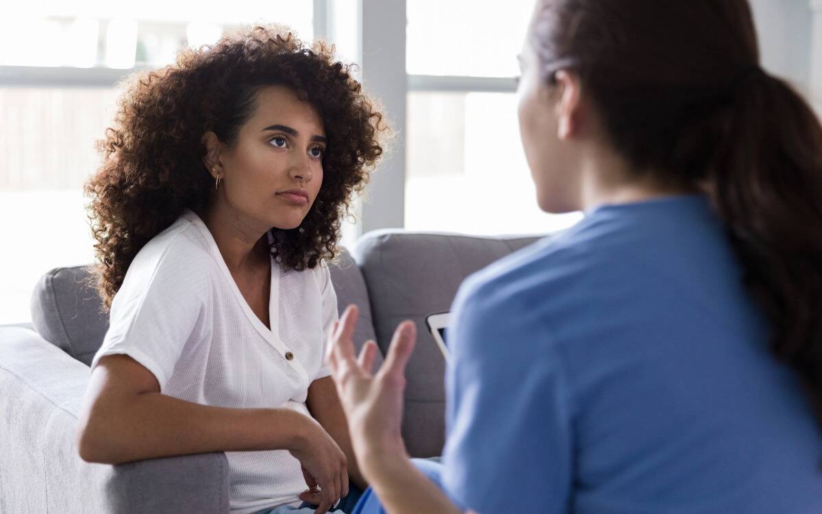 Two women talking, with one woman looking unimpressed.