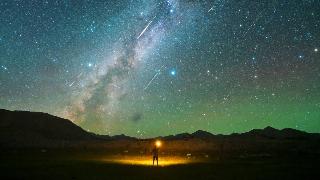 A man watches the Perseid meteor shower on the Pamir Plateau on August 13, 2021 in Xinjiang Uygur Autonomous Region of China.