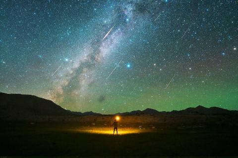 A man watches the Perseid meteor shower on the Pamir Plateau on August 13, 2021 in Xinjiang Uygur Autonomous Region of China.