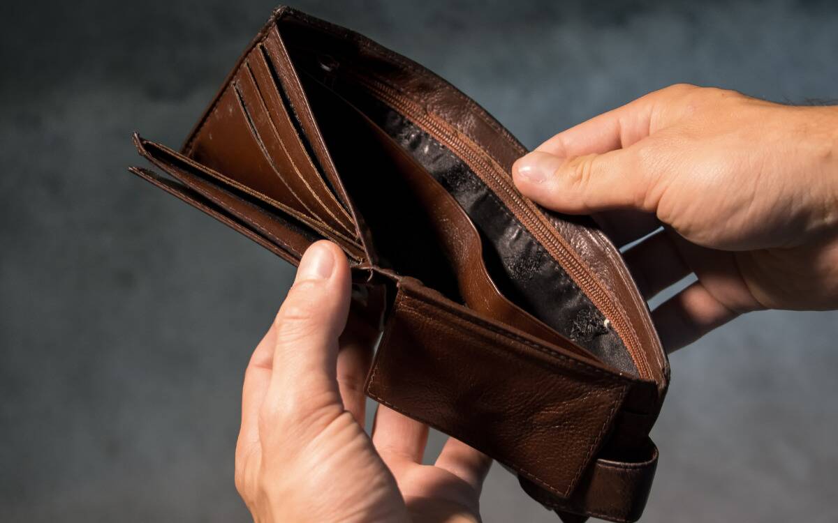A man holding open an empty wallet.
