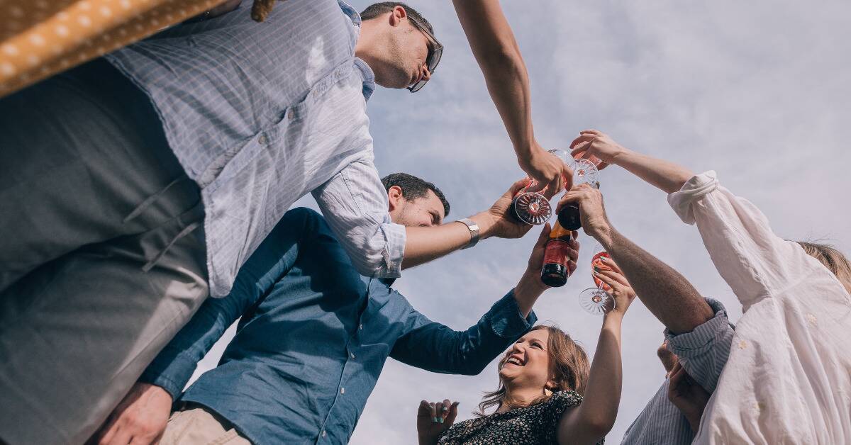 A low shot of a group of friends cheersing.
