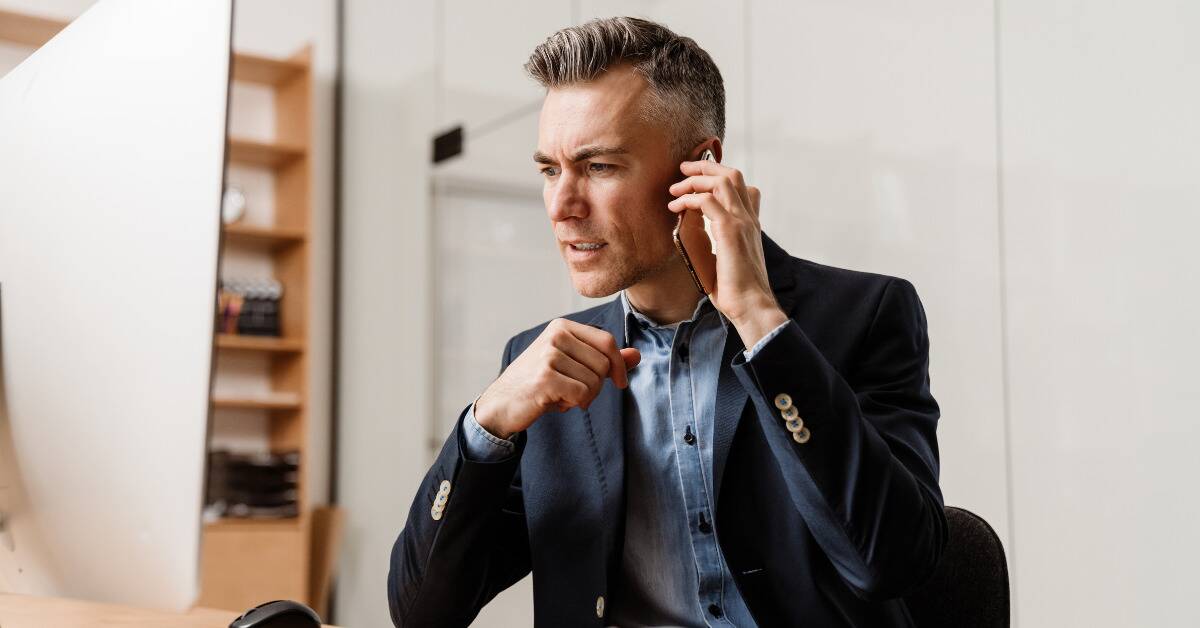 A man on the phone looking tense.