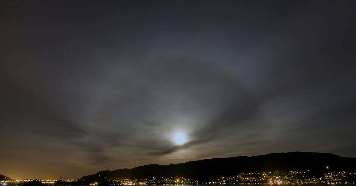 A lunar halo with a bigger, fuzzier halo, centered over a town.