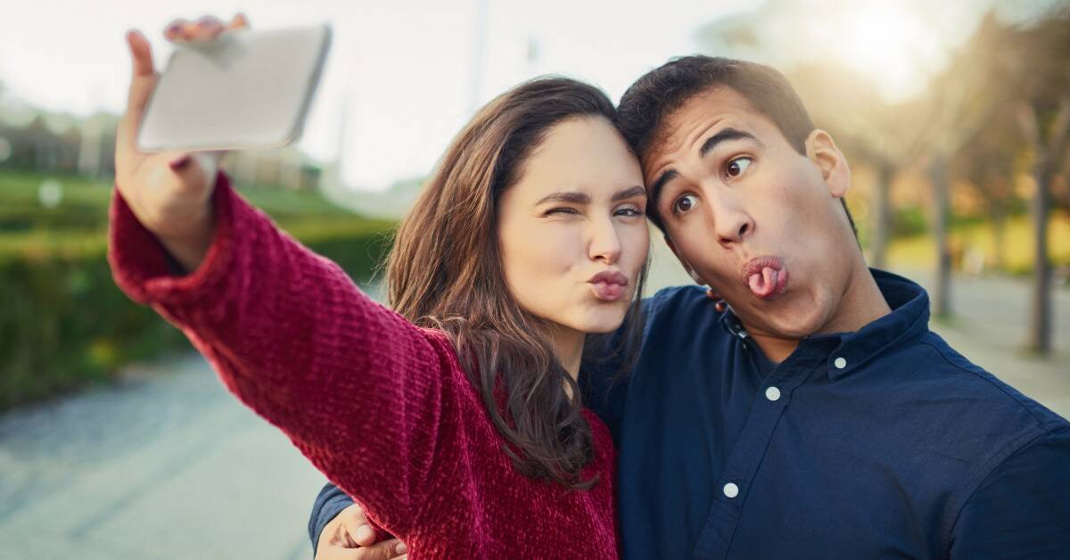 A couple each making a silly face for a sefie.