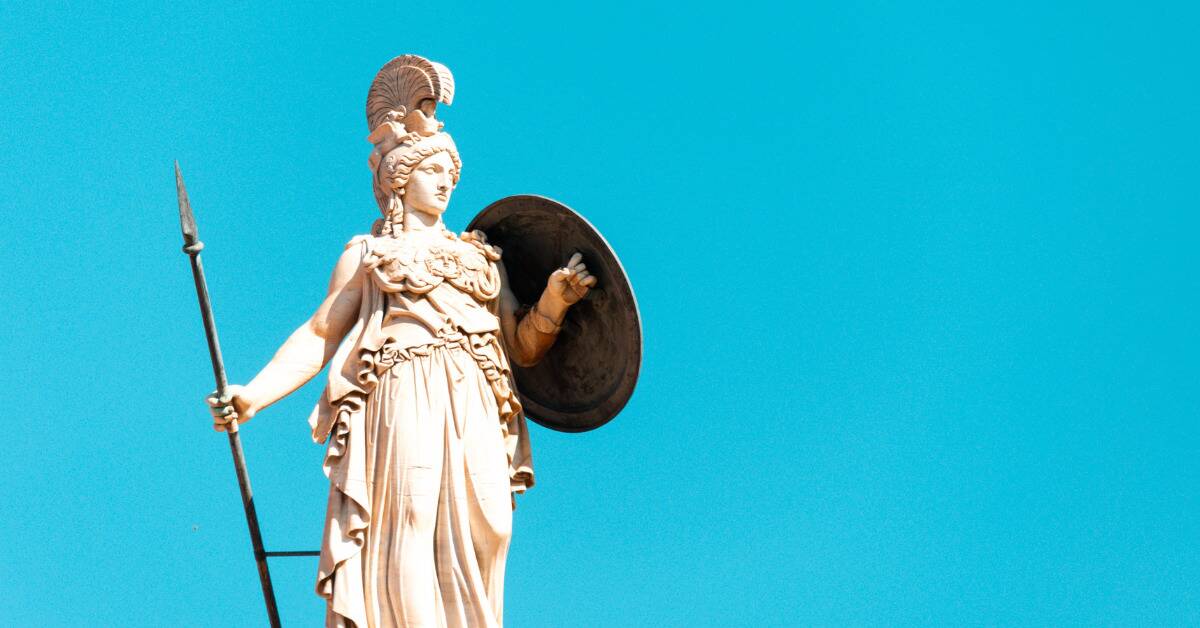A statue of the goddess Athena against a bright blue backdrop.