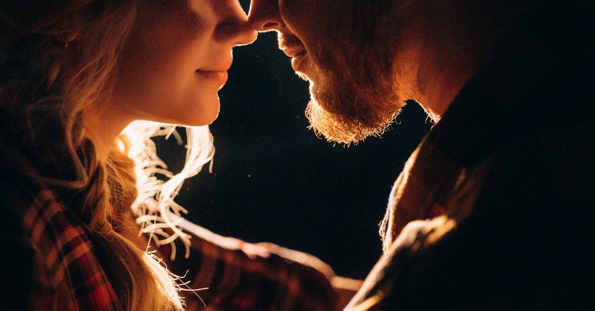 A close shot of a couple whose faces are very close together as they embrace.