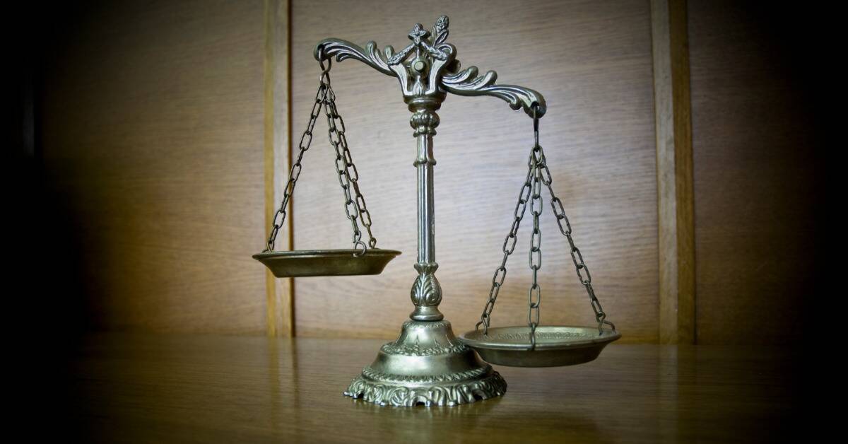 The scales of justice on a wooden desk.