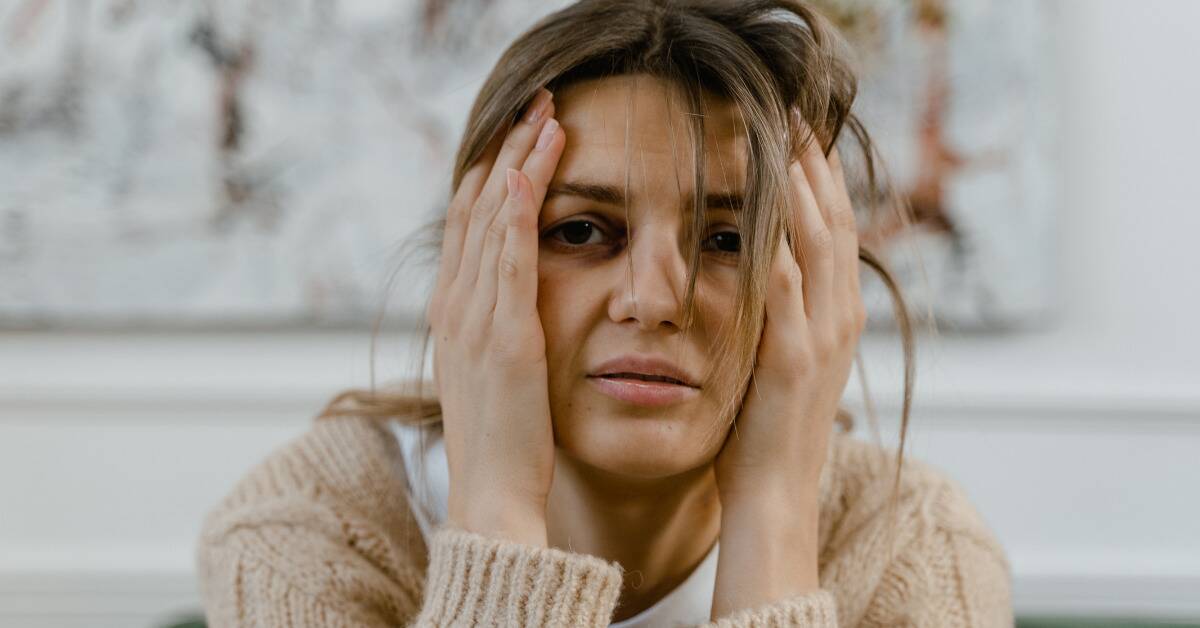 A woman holding both sides of her face.