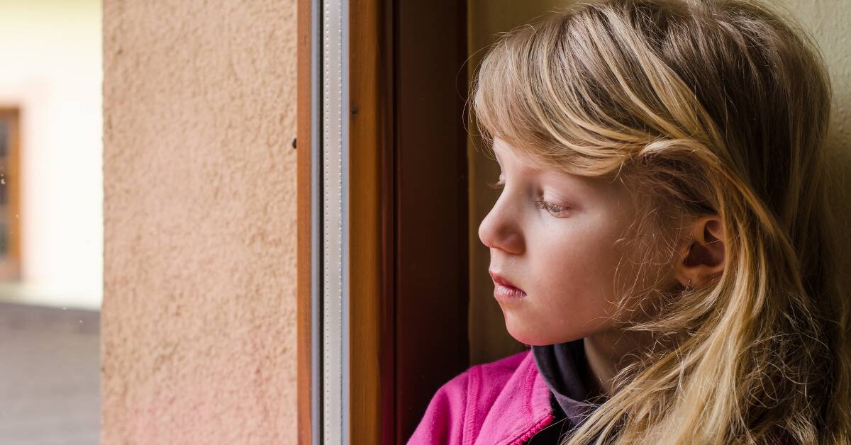 A young girl looking forlorn and contemplative.