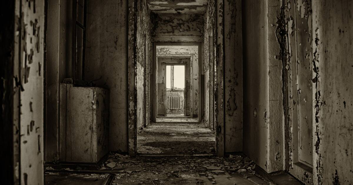 A straight shot down the hallway of a dingy, abandoned building.