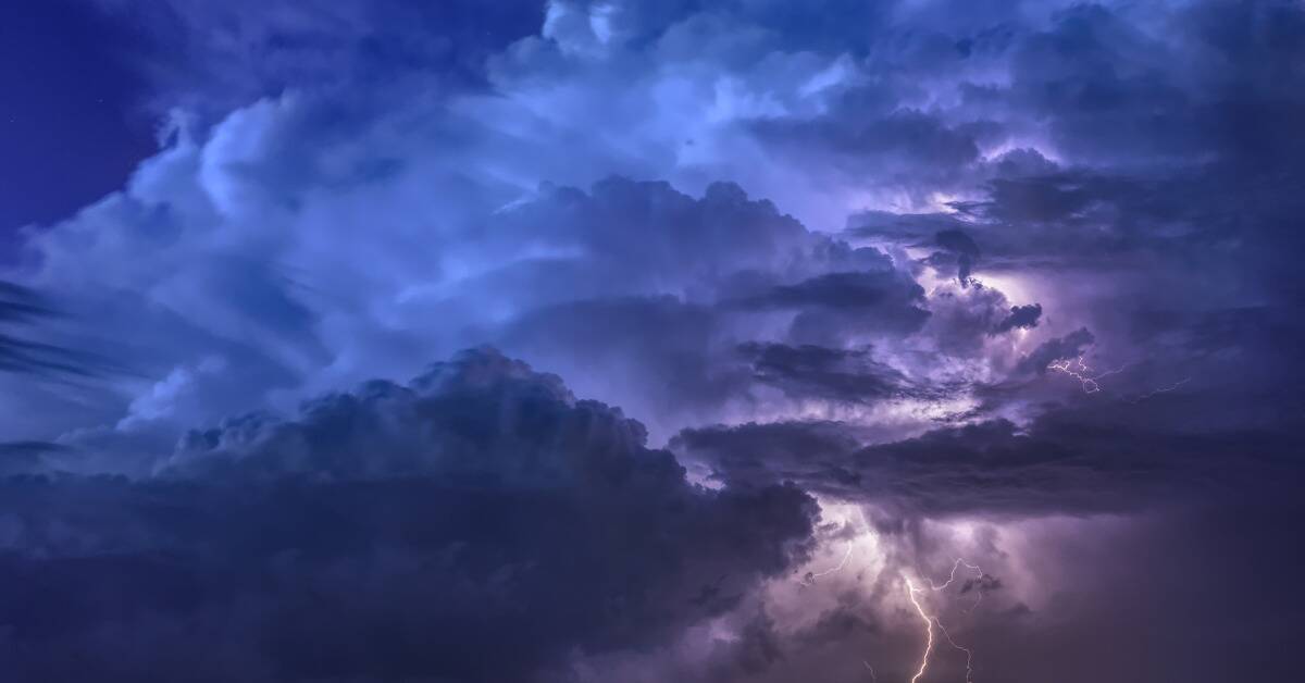 A sky filled with blue and purple clouds, lightning striking in the bottom right corner.