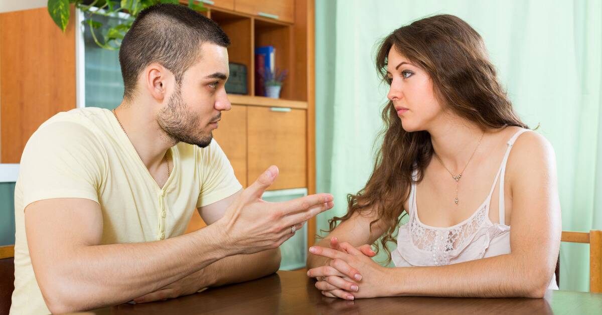 A couple seated at a table having a serious conversation.