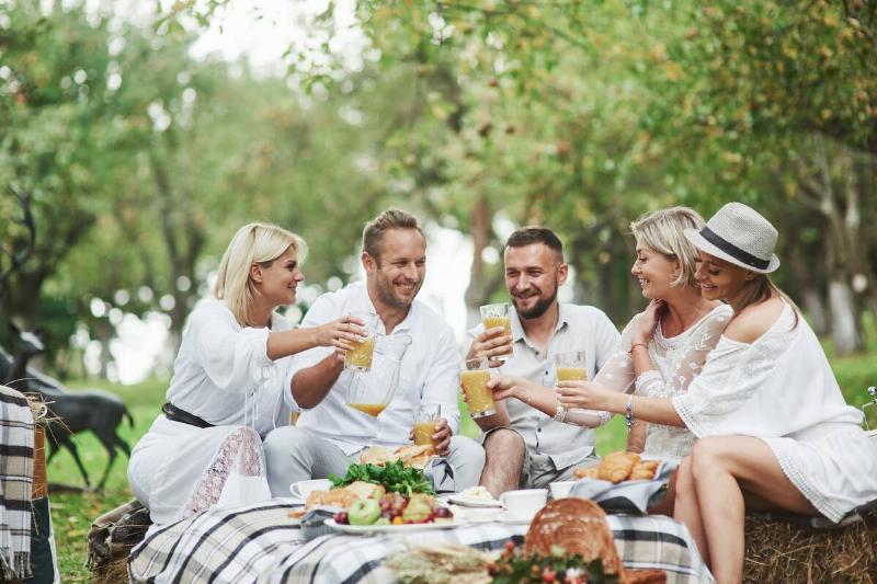 group of adults in all white sitting outside having brunch