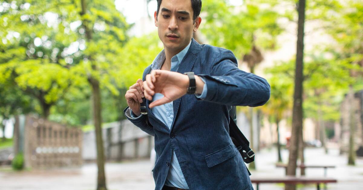 A man checking his watch, clearly running late.