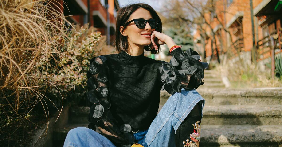 A woman in unique fashion posed on a staircase.