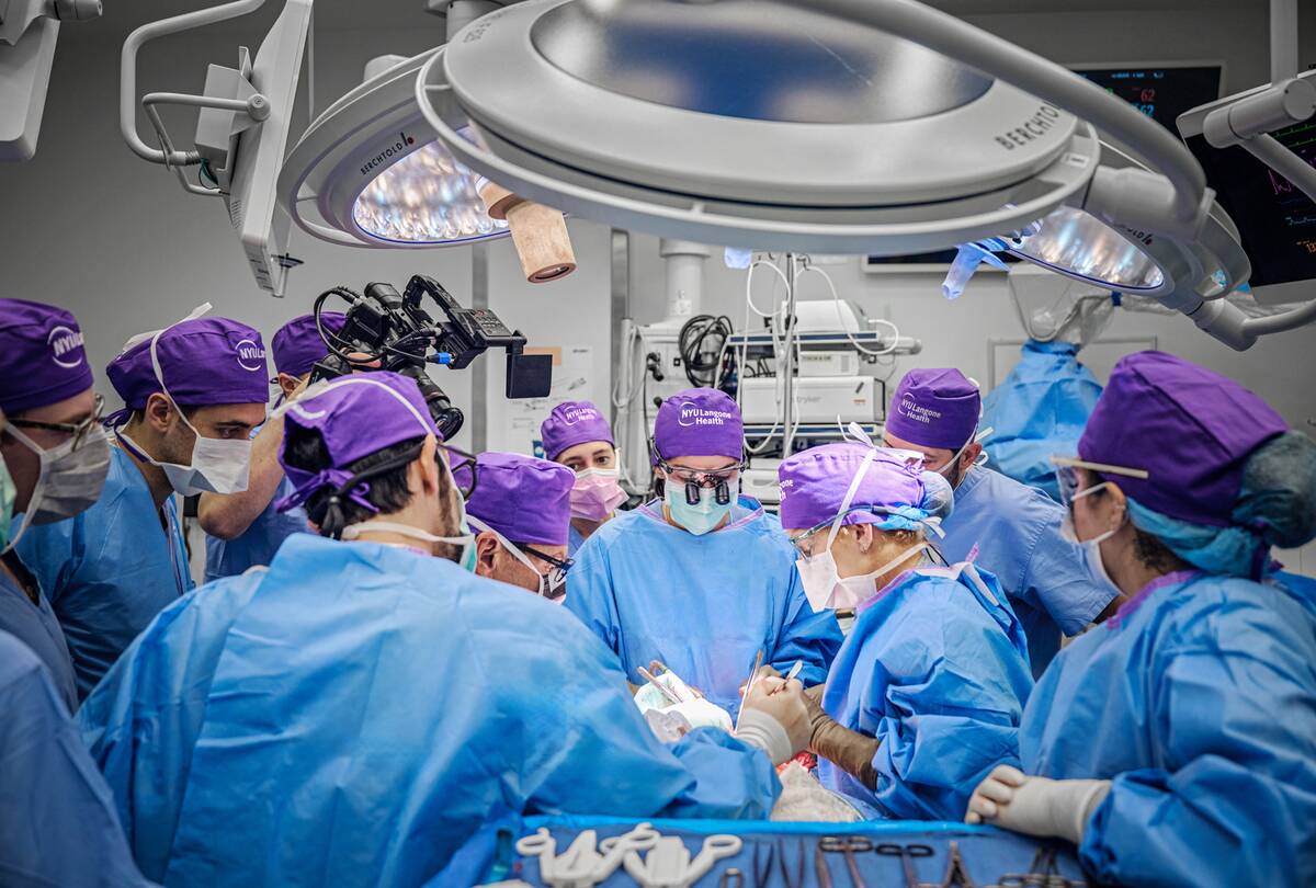 A photo taken during Aaron's surgery, a large group of surgeons surrounding his body.