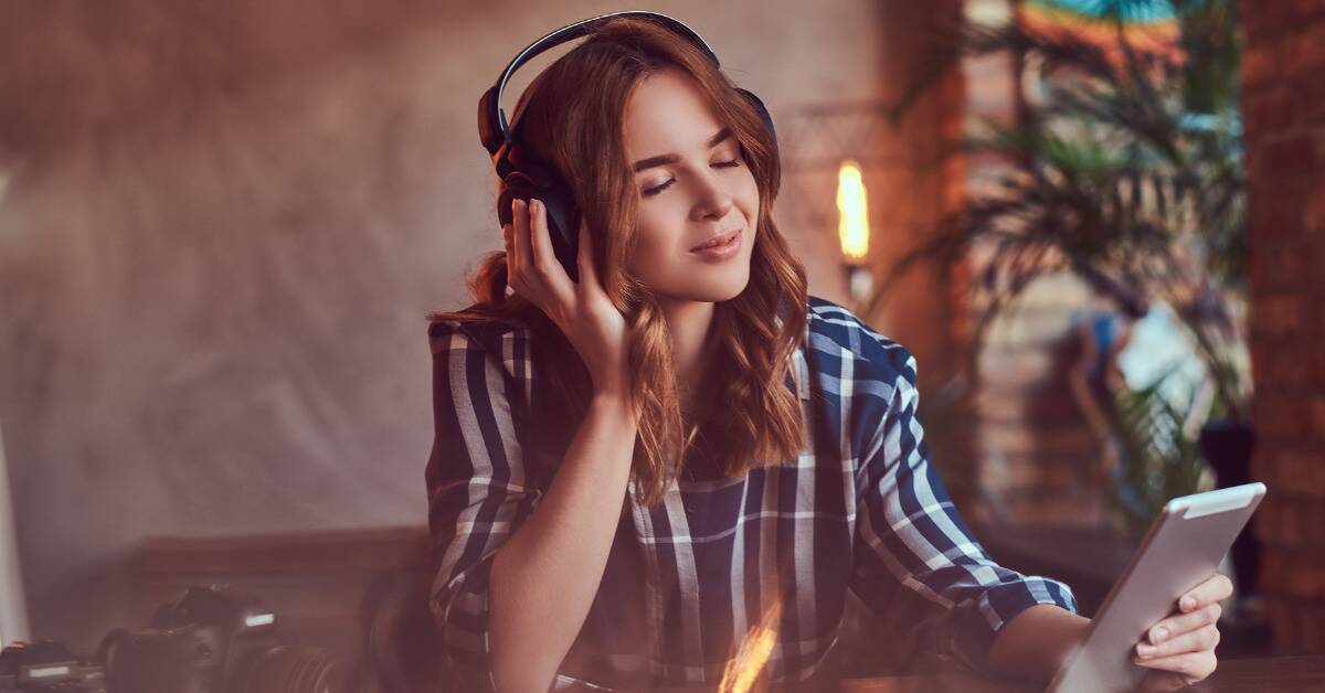 A woman listening to something on her headphones, seeming peaceful.