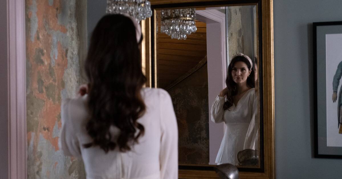 A woman admiring herself in a mirror.