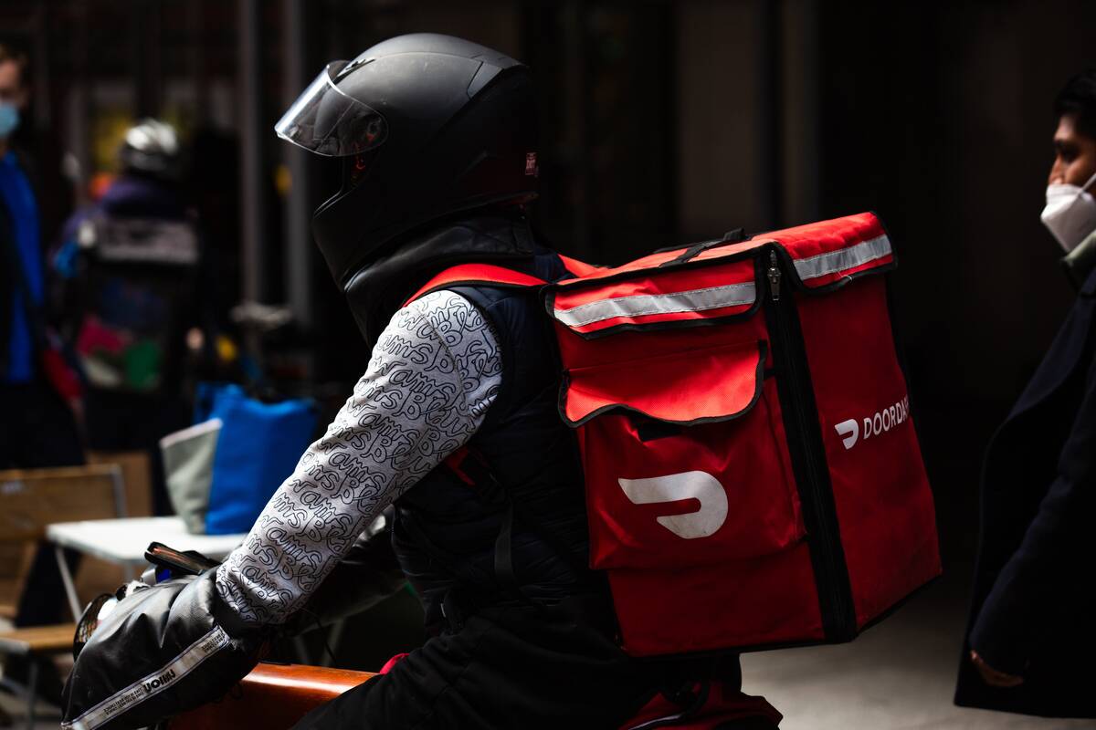 A demonstrator wearing a Doordash backpack in Times Square during a march for food delivery workers rights in New York, U.S., on Wednesday, April 21, 2021. Delivery workers are calling on the city to grant them further labor protections, including enhanced safety provisions, access to bathrooms, and more regulation of the apps, Gothamist reports.