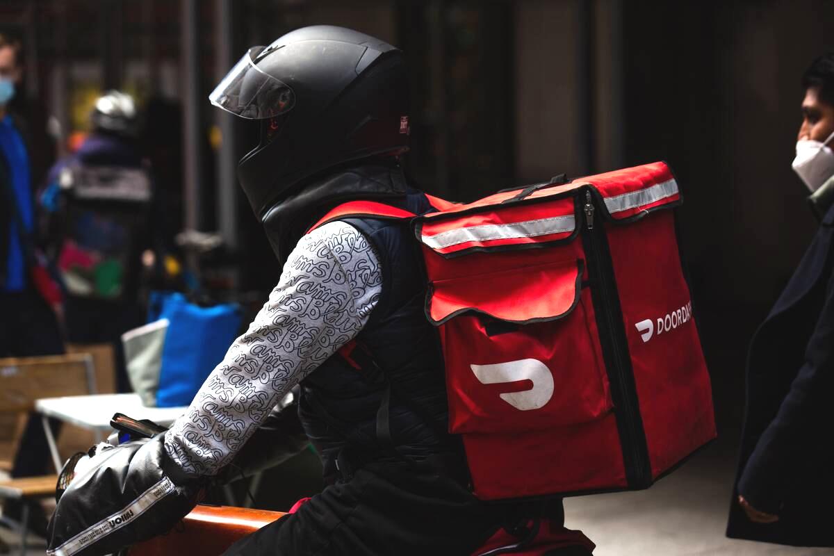 A demonstrator wearing a Doordash backpack in Times Square during a march for food delivery workers rights in New York, U.S., on Wednesday, April 21, 2021. Delivery workers are calling on the city to grant them further labor protections, including enhanced safety provisions, access to bathrooms, and more regulation of the apps, Gothamist reports.