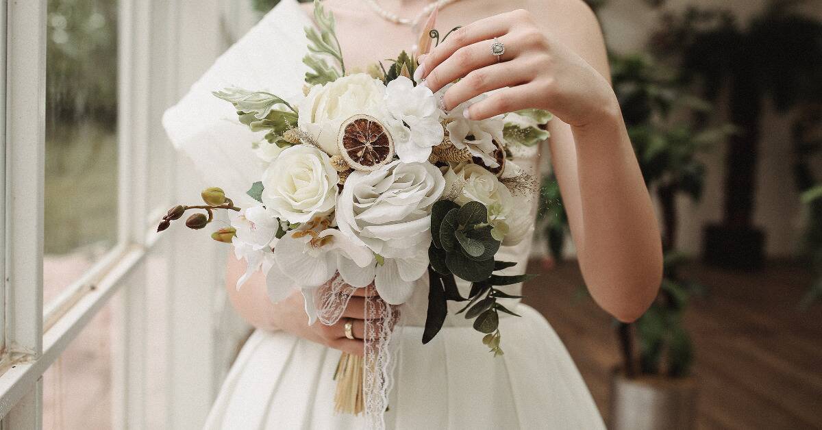 A closeup torso shot of a bride holding her wedding bouquet.