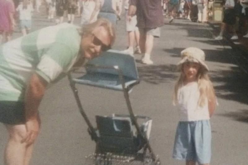 A childhood photo of Freya standing next to her dad.