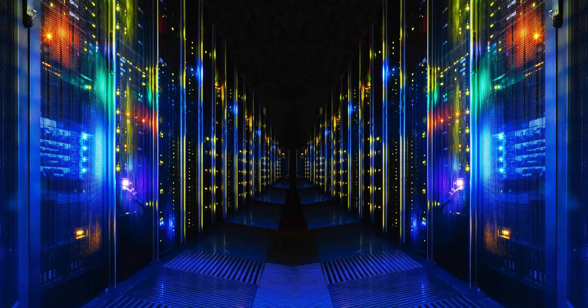 A shot down a dark hallway lined with lit up computer servers.
