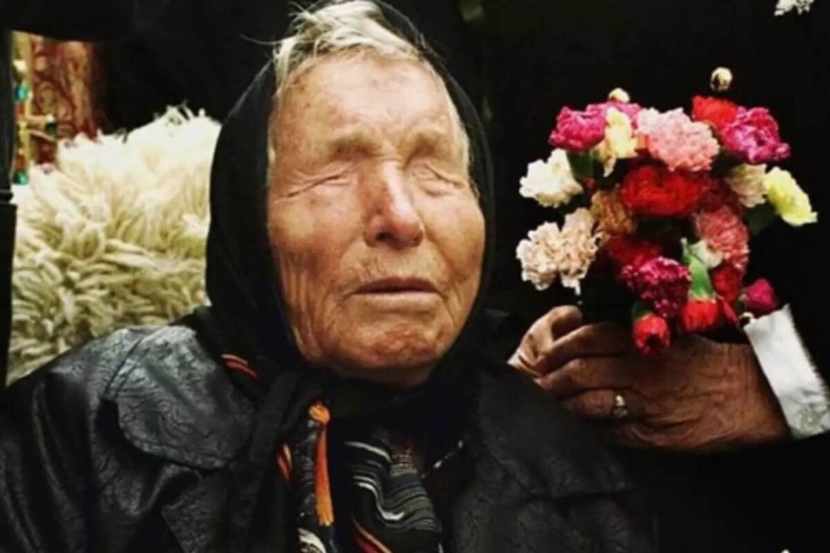 Baba Vanga sitting next to someone who's holding a bouquet of flowers next to her head.