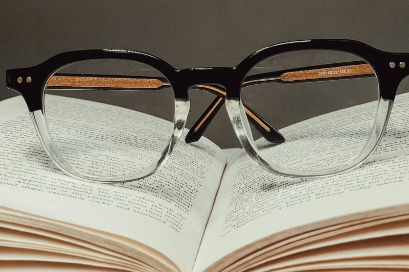 A pair of glasses resting on an open book
