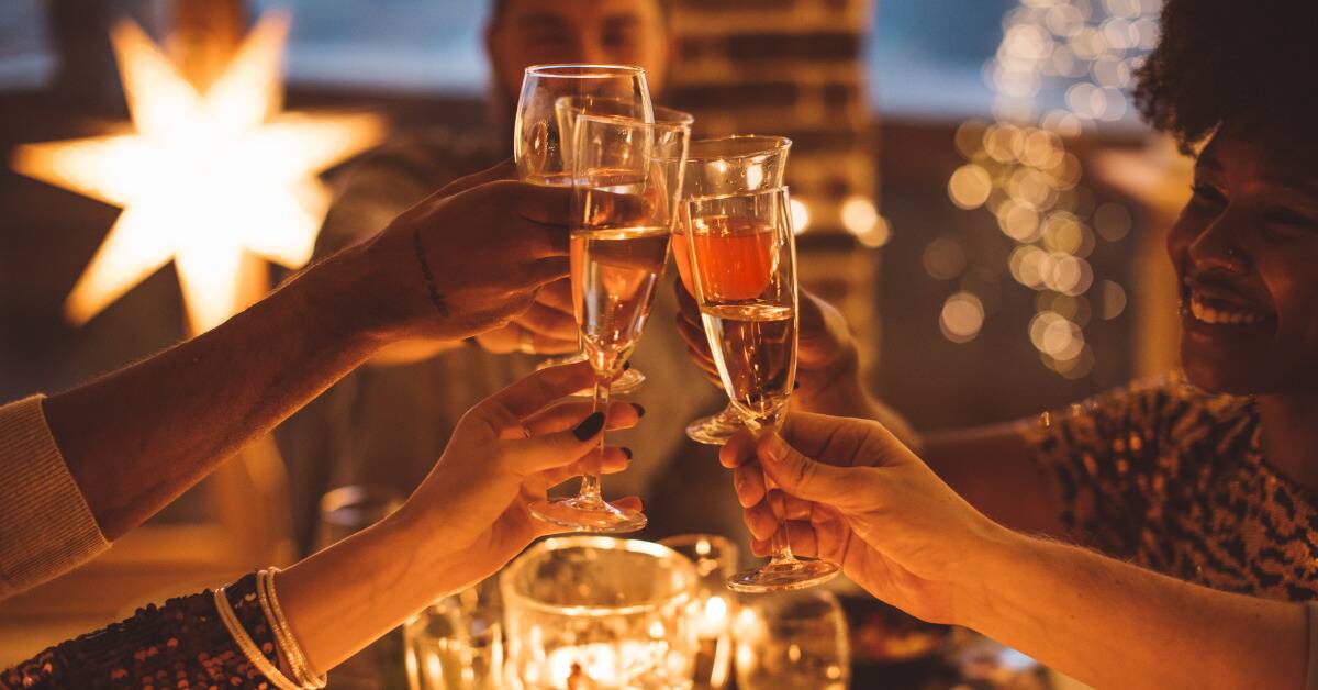 People clinking glasses of champagne at a NYE party.