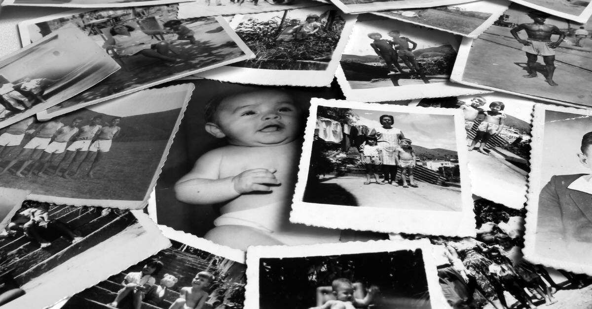 An array of black and white photographs scattered on a table.