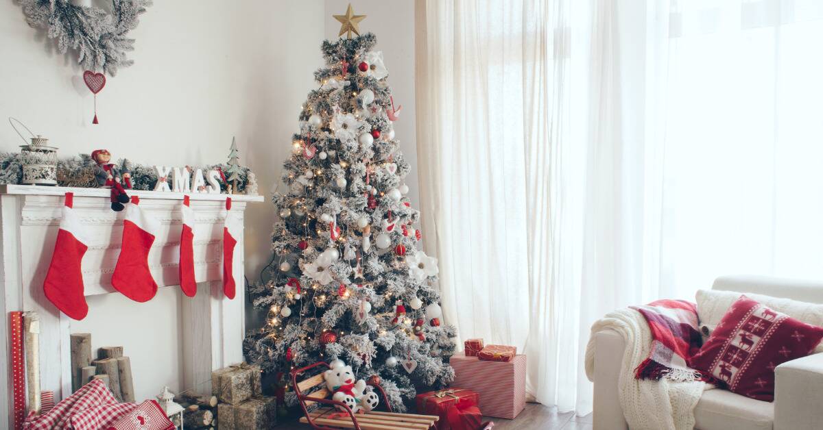 A white and red monochromatically decorated tree in a similarly colored/decorated living room.