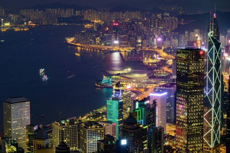 A drone shot of Hong Kong at night, with all the buildings lit up.