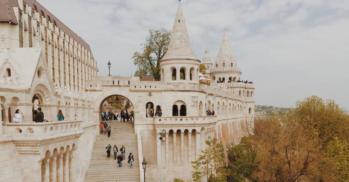 A castle in Budapest with tourists walking around.