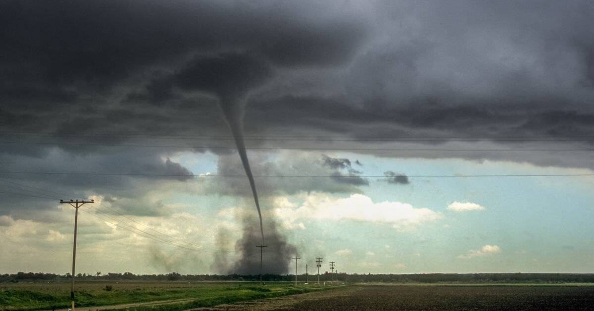 A tornado running through a farm field.